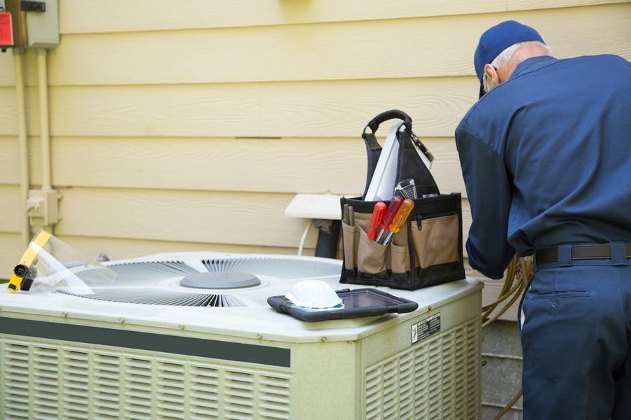 Technician inspecting an AC unit.