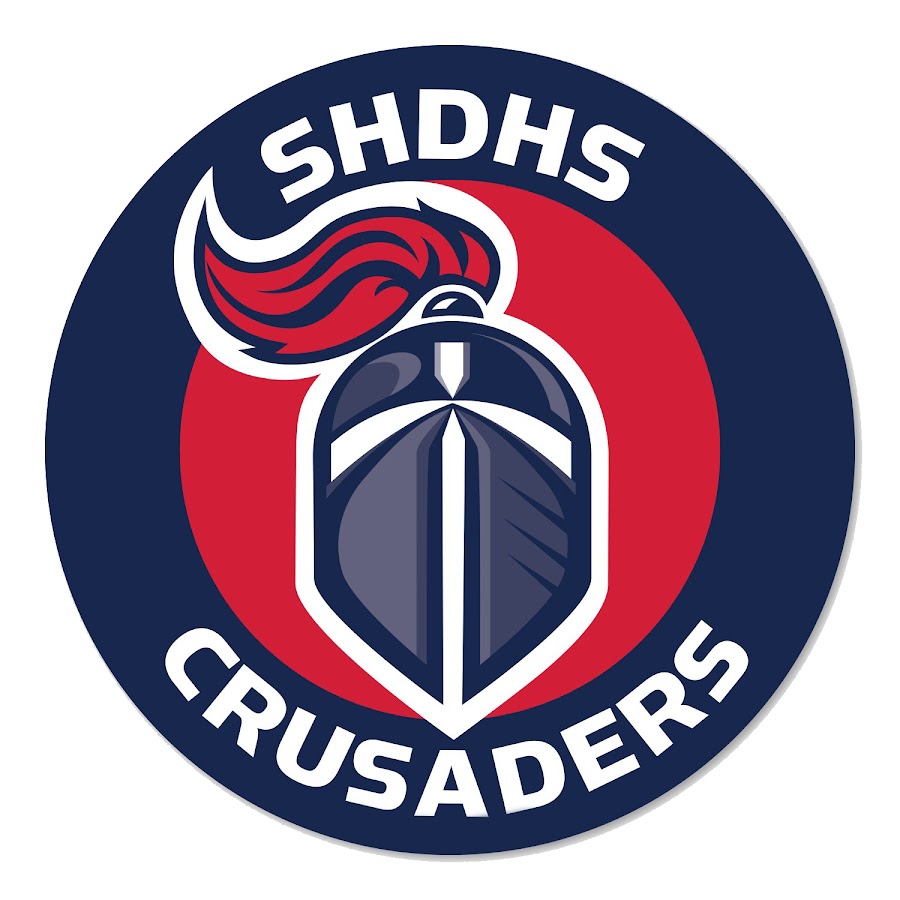Circular SHDHS Crusaders logo with a blue knight helmet and red flame inside a navy ring, conveying the team branding.