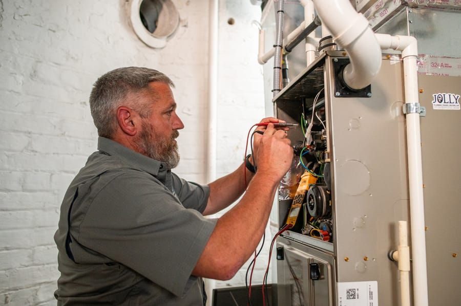 Technician professional electrical repairs on an HVAC system.