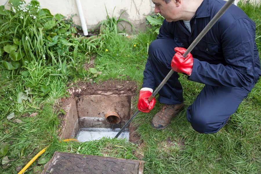 Plumber unclogging a drain with professional tools.