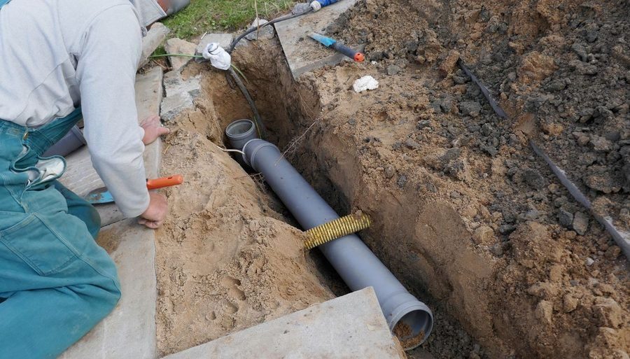 Sewer line showing through trench dug for sewer repairs.