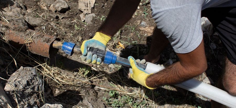 Plumber connecting a water line to repair flow.