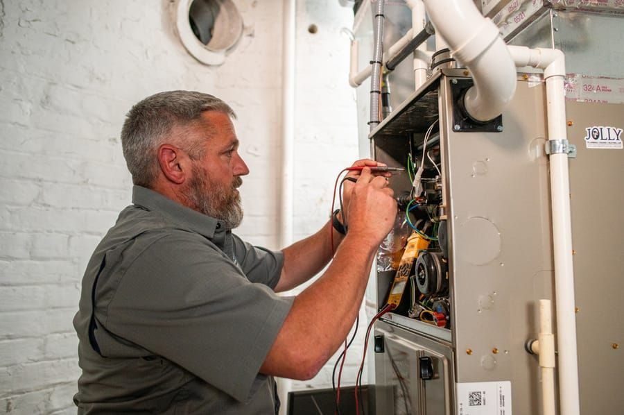 Technician professional electrical repairs on an HVAC system.